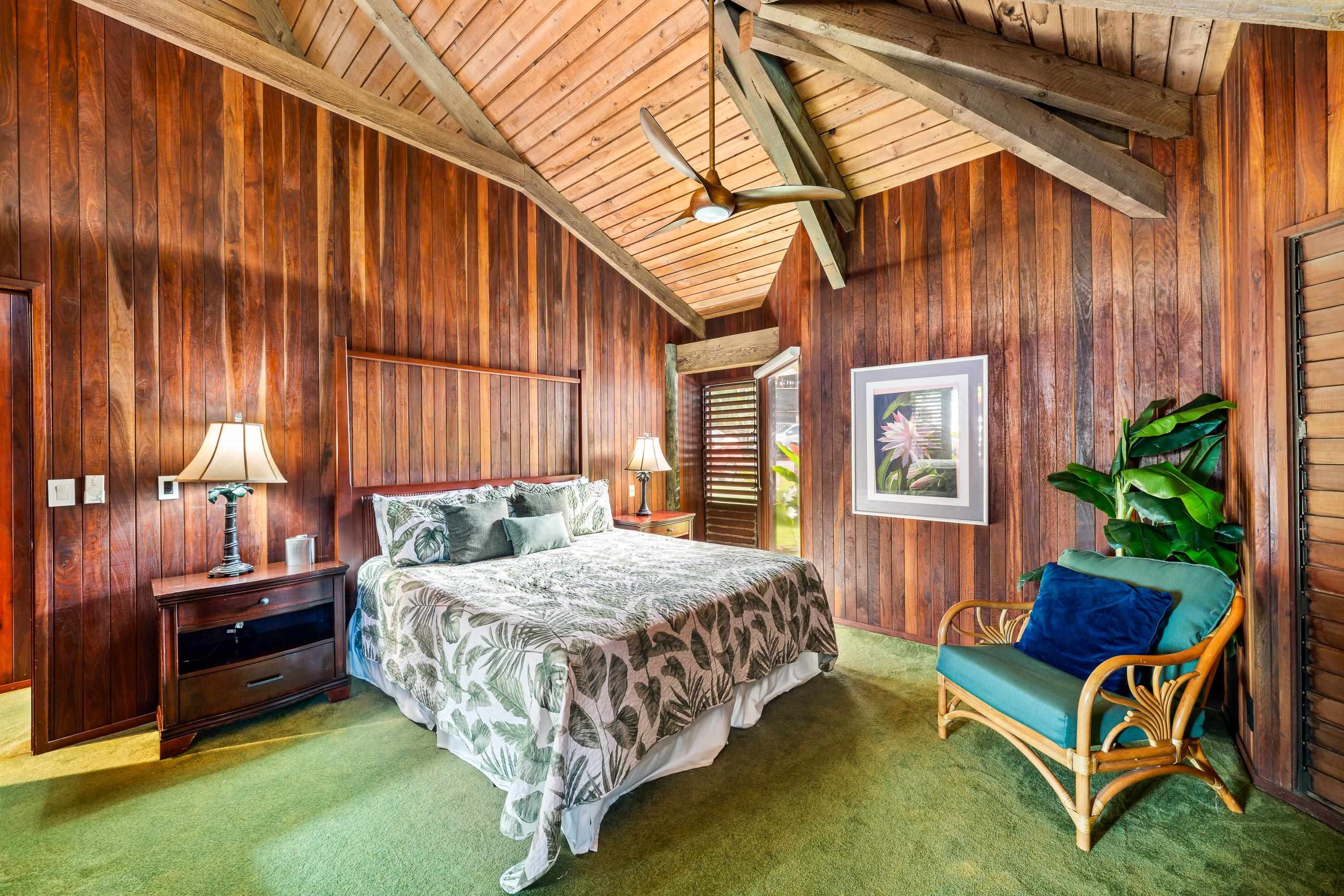 Bedroom with reading lamp and island art, a blue armchair in the corner